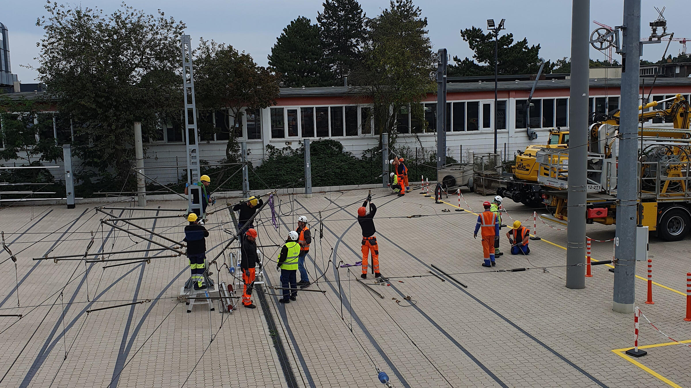 Eine Gruppe Monteure arbeitet an Oberleitungen.