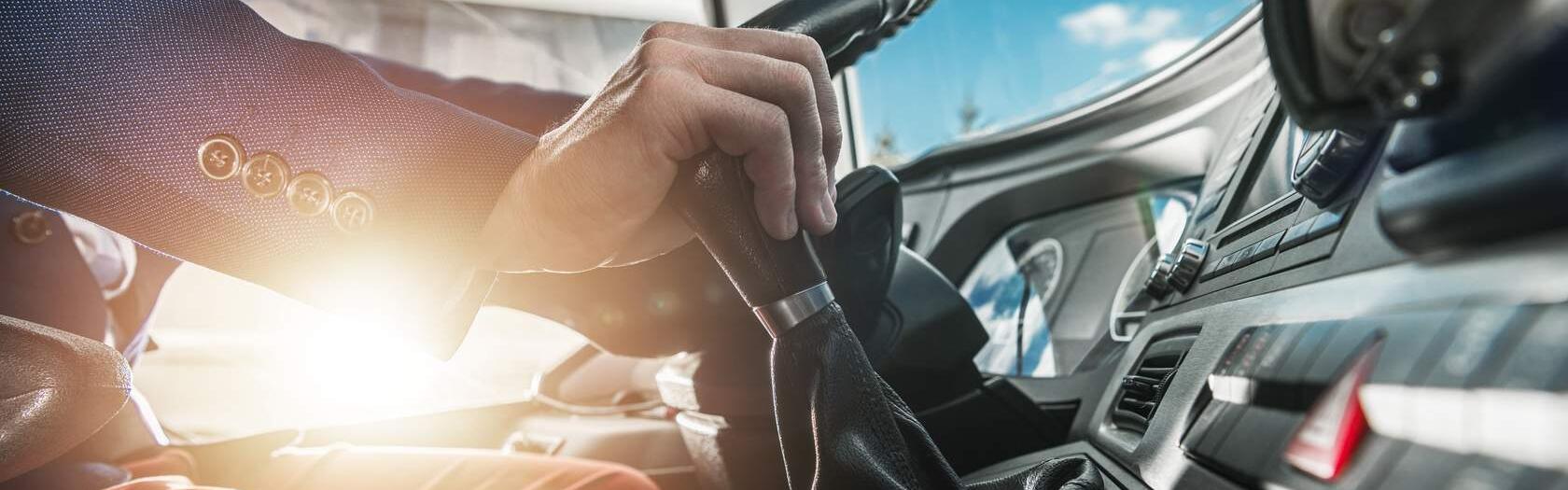 Man sieht die Hände einer Person, die einen Bus lenkt.