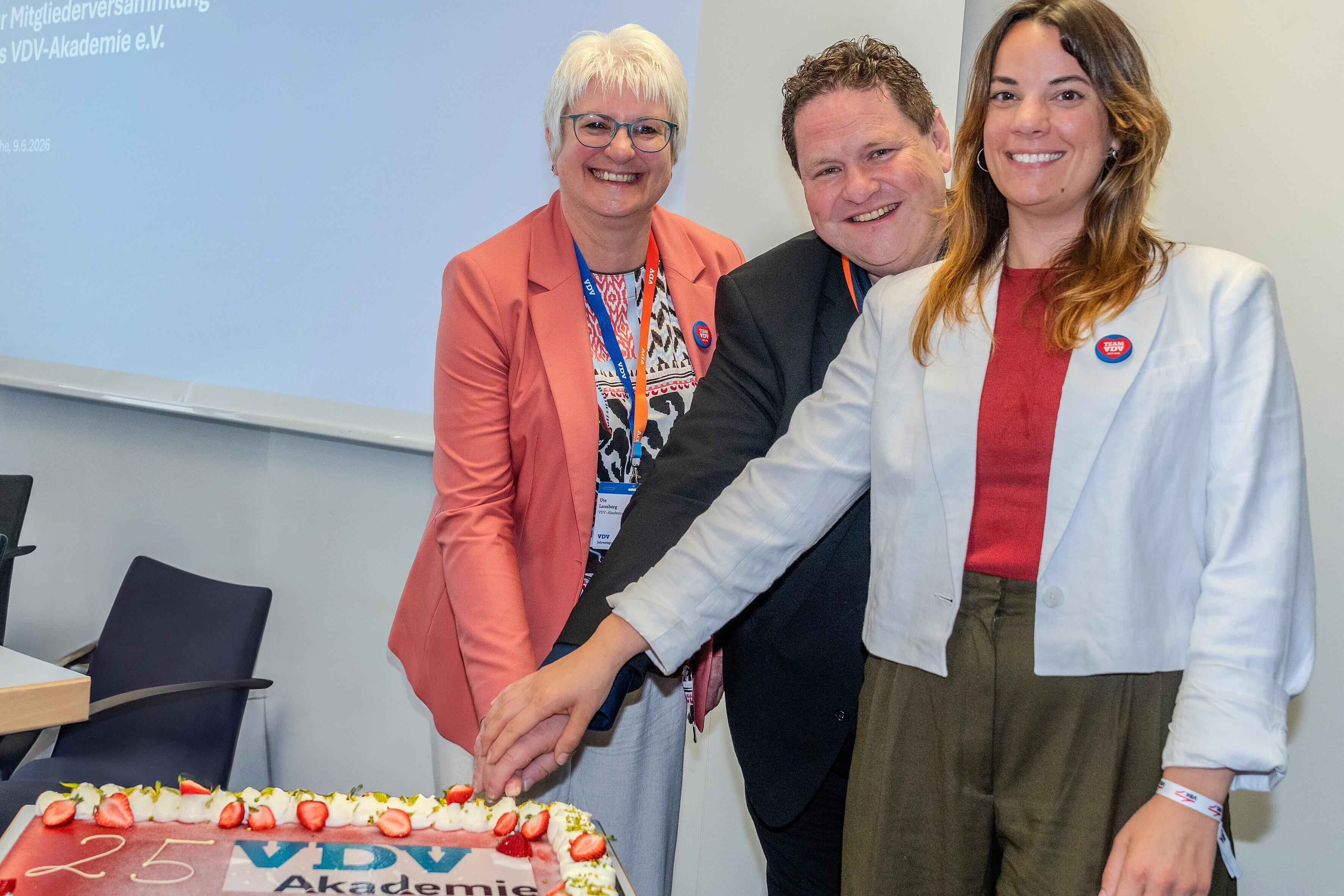 Der Vorstandsvorsitzende und die beiden vor Ort "dienstältesten" Kolleginnen schneiden die Jubiläumstorte an: Ute Lausberg (l.), Harald Kraus und Britta Robels.