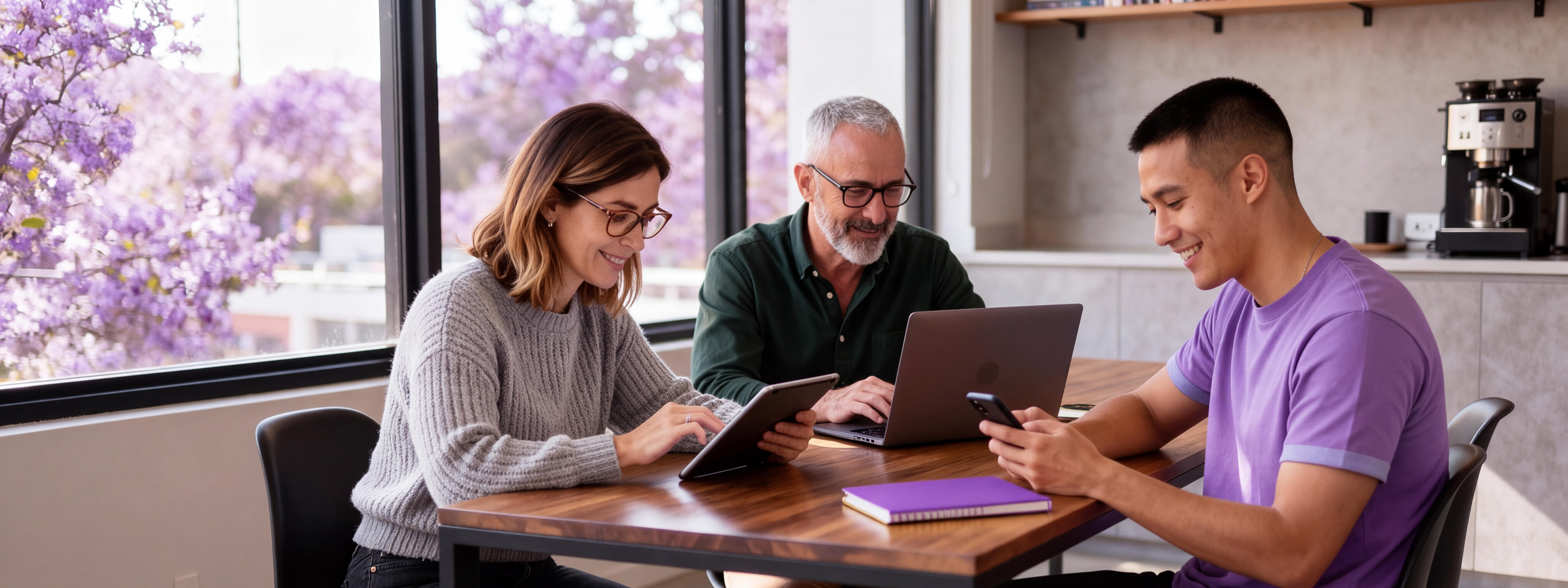 Eine Frau und zwei Männer bei der Arbeit mit digitalen Geräten
