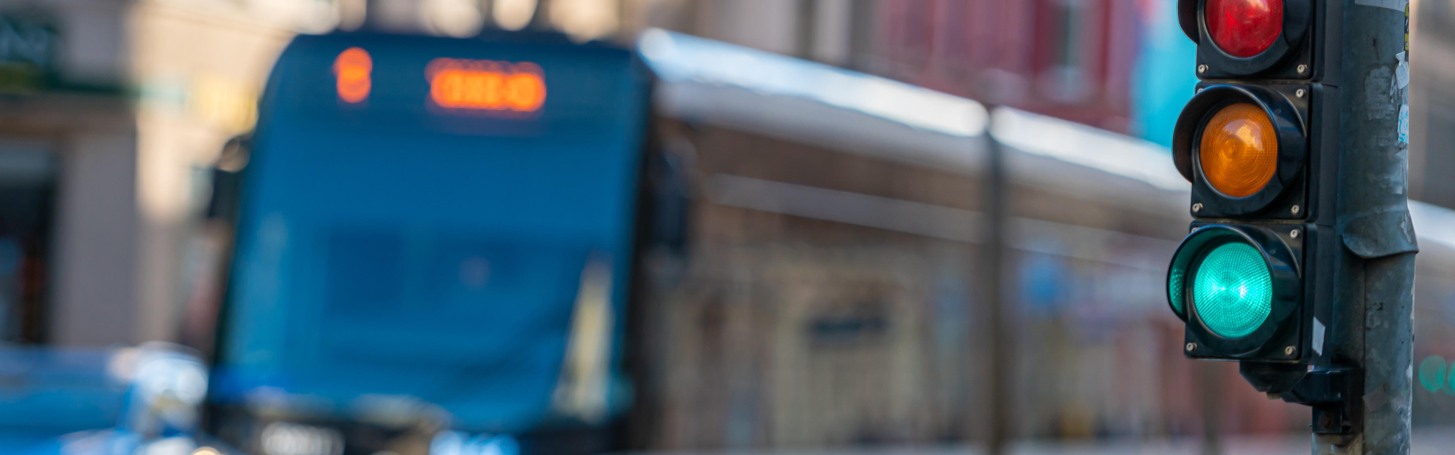 Eine Straßenbahn fährt im Hintergrund an einer grünen Fahrradampel vorbei.