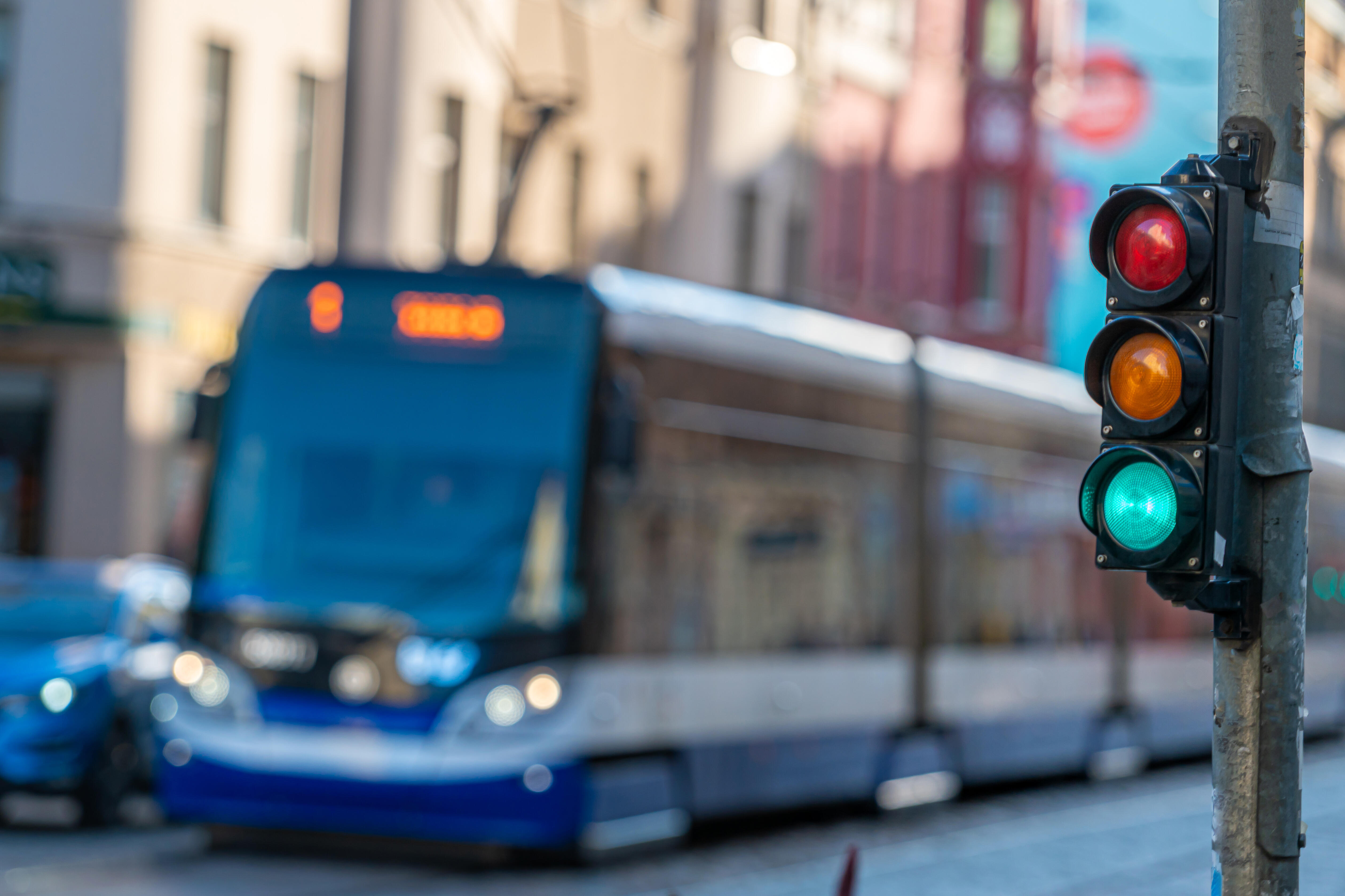 Eine Straßenbahn fährt im Hintergrund an einer grünen Fahrradampel vorbei.