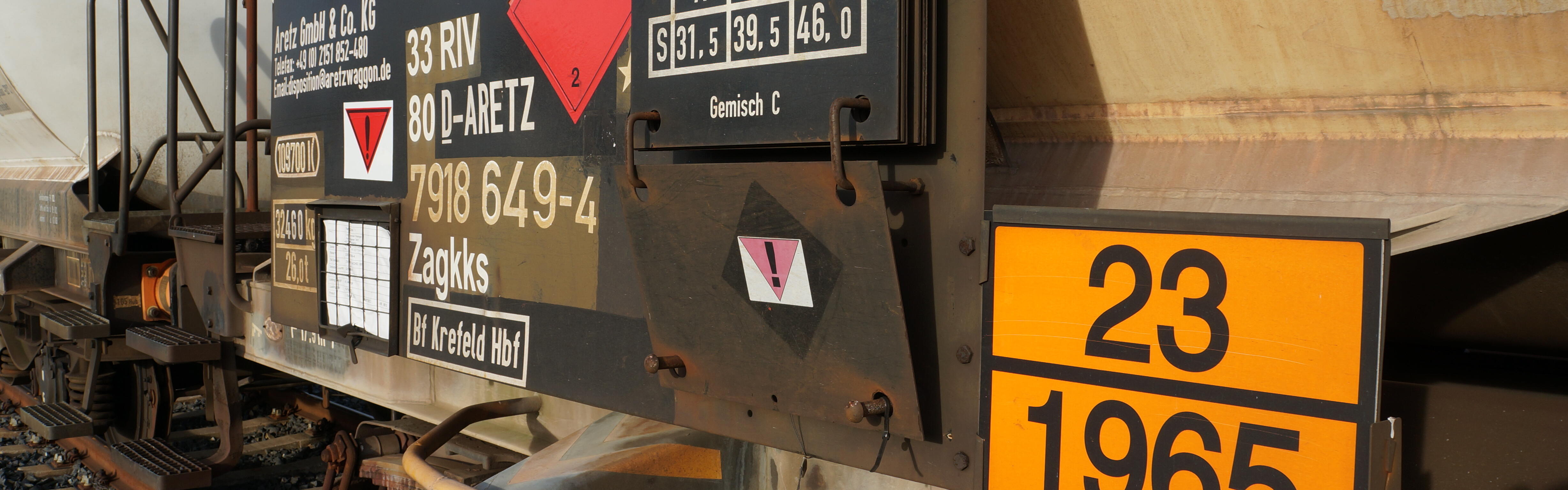 Warntafeln mit Hinweisen auf Gefahrenstoffe sind an einem Kesselwagen befestigt