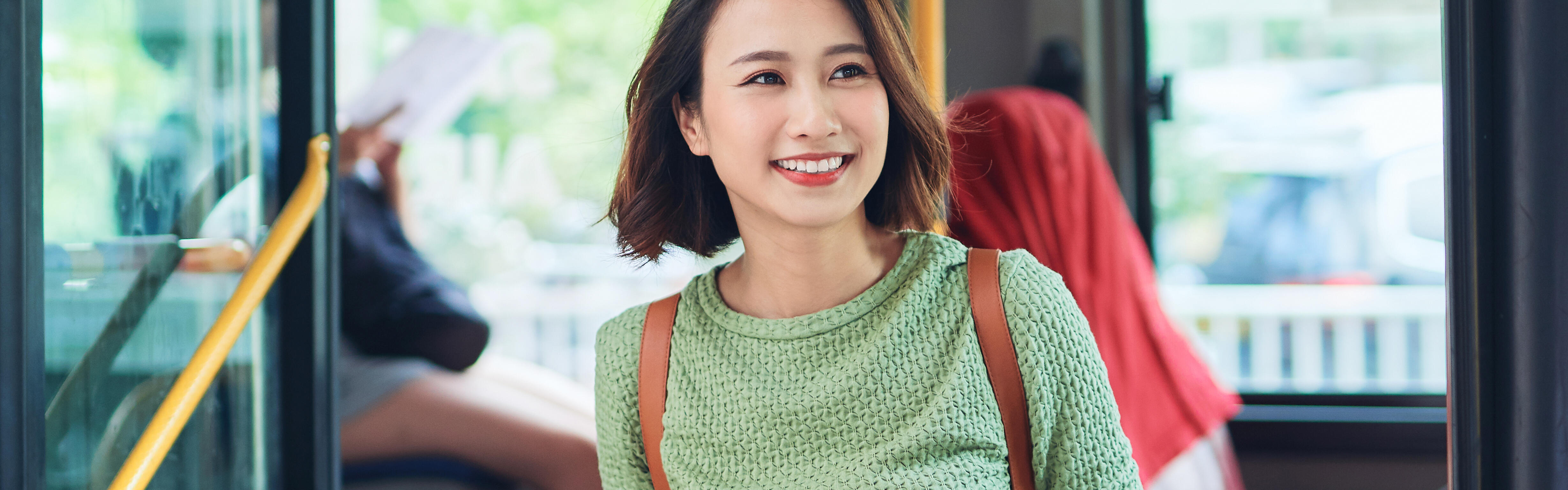 Junge Reisende steigt aus einem Bus aus.