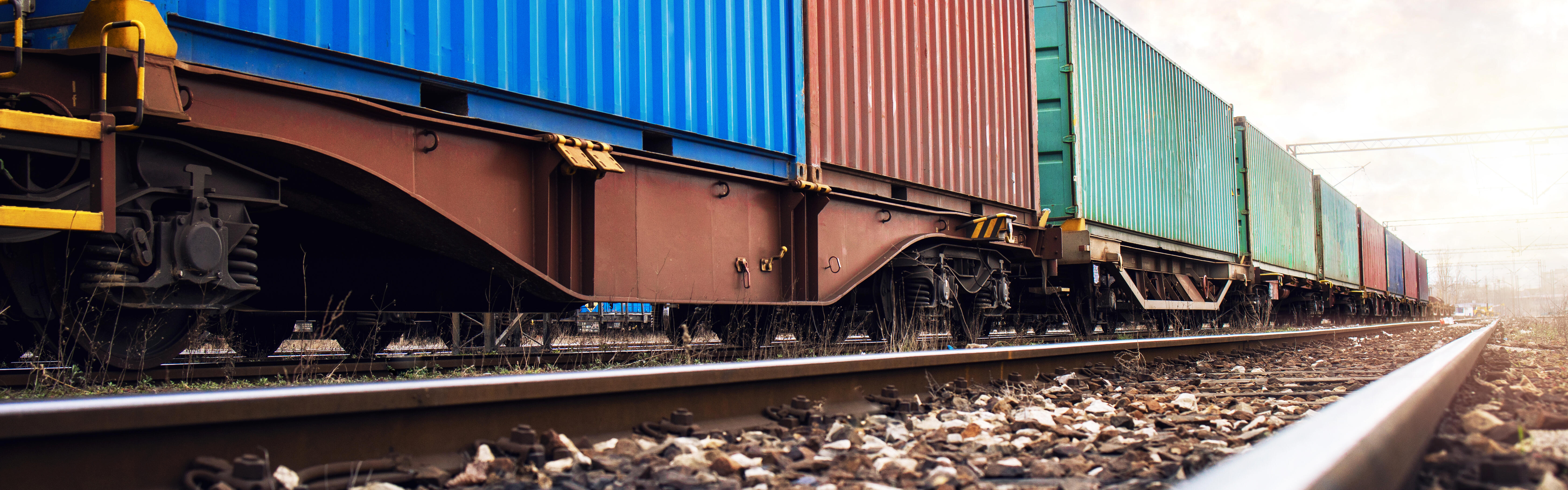 Ein Güterzug mit Container beladen fährt über eine Eisenbahnstrecke.