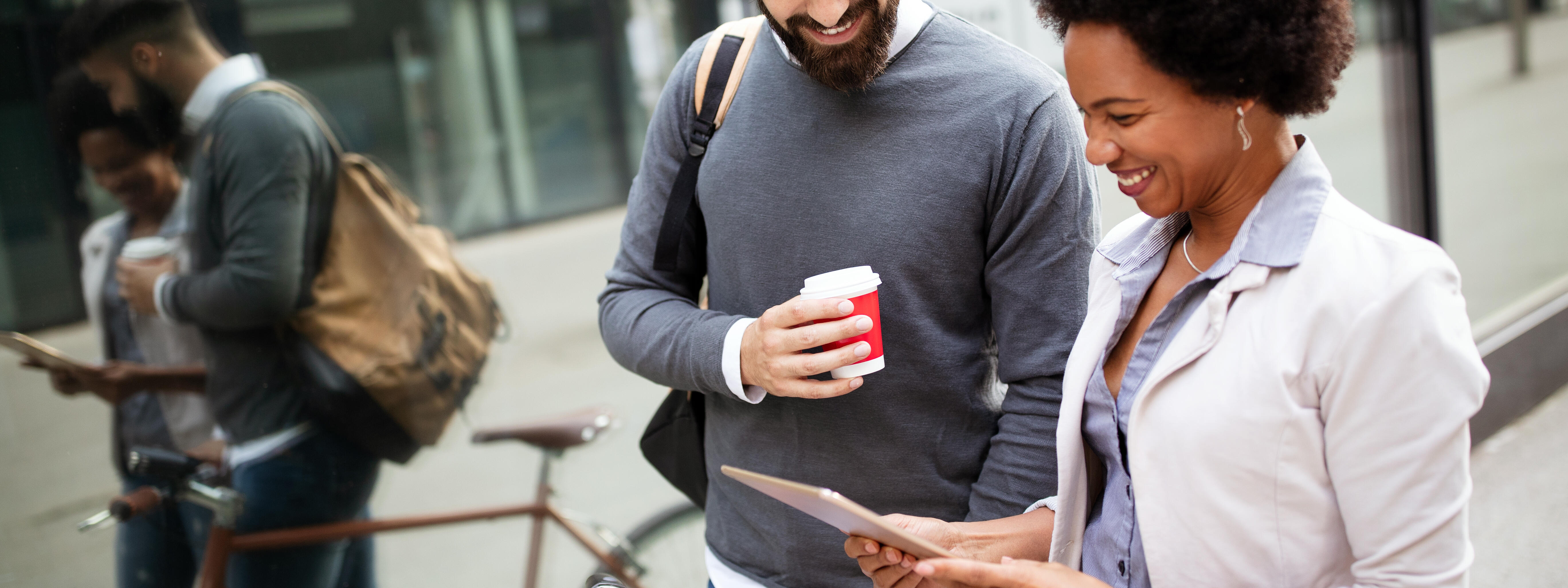 Ein Mann mit einem Fahrrad und eine Dame stehen neben einer Straßenbahn