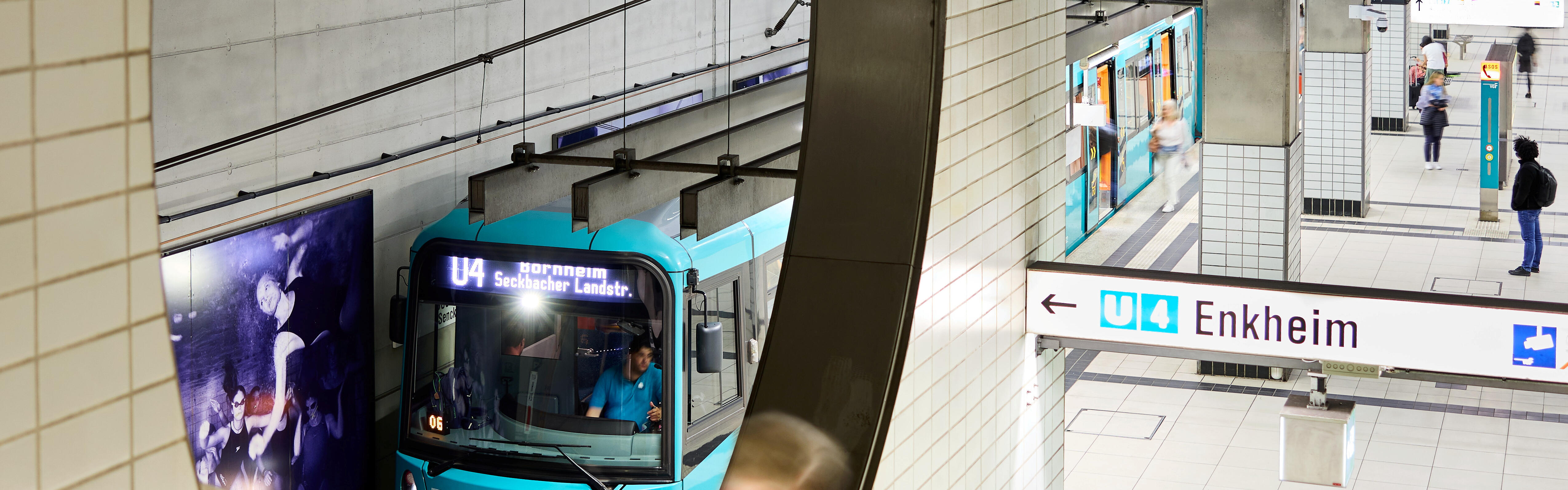 Eine Bahn der Linie U4 (Typ U5) am Bahnsteig der Bockenheimer Warte. Es sind Fahrgäste sowie die Treppen abgebildet.