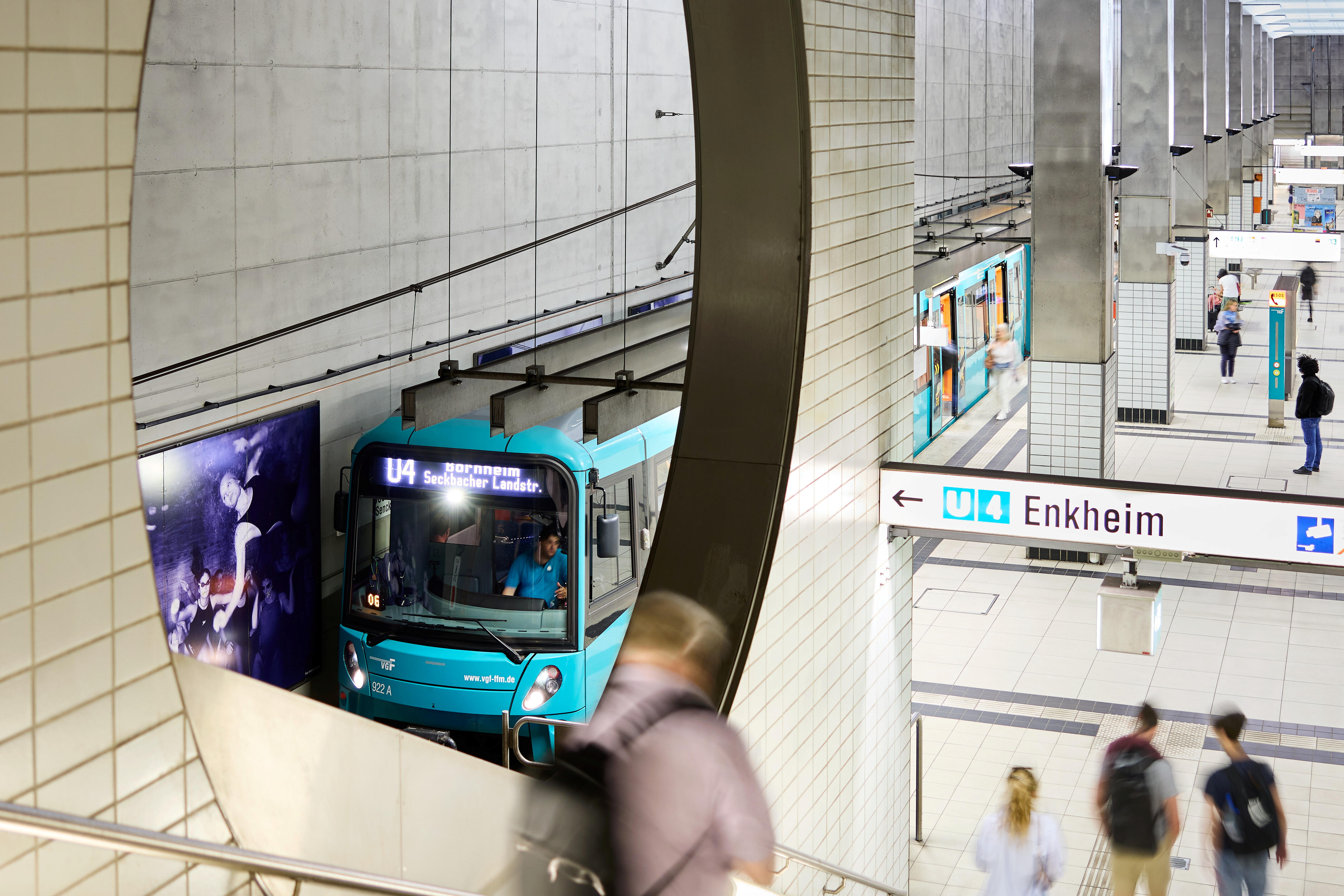 Eine Bahn der Linie U4 (Typ U5) am Bahnsteig der Bockenheimer Warte. Es sind Fahrgäste sowie die Treppen abgebildet.